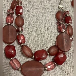 Plum colored beads on a silver tone necklace with matching earrings. Claw clasp.